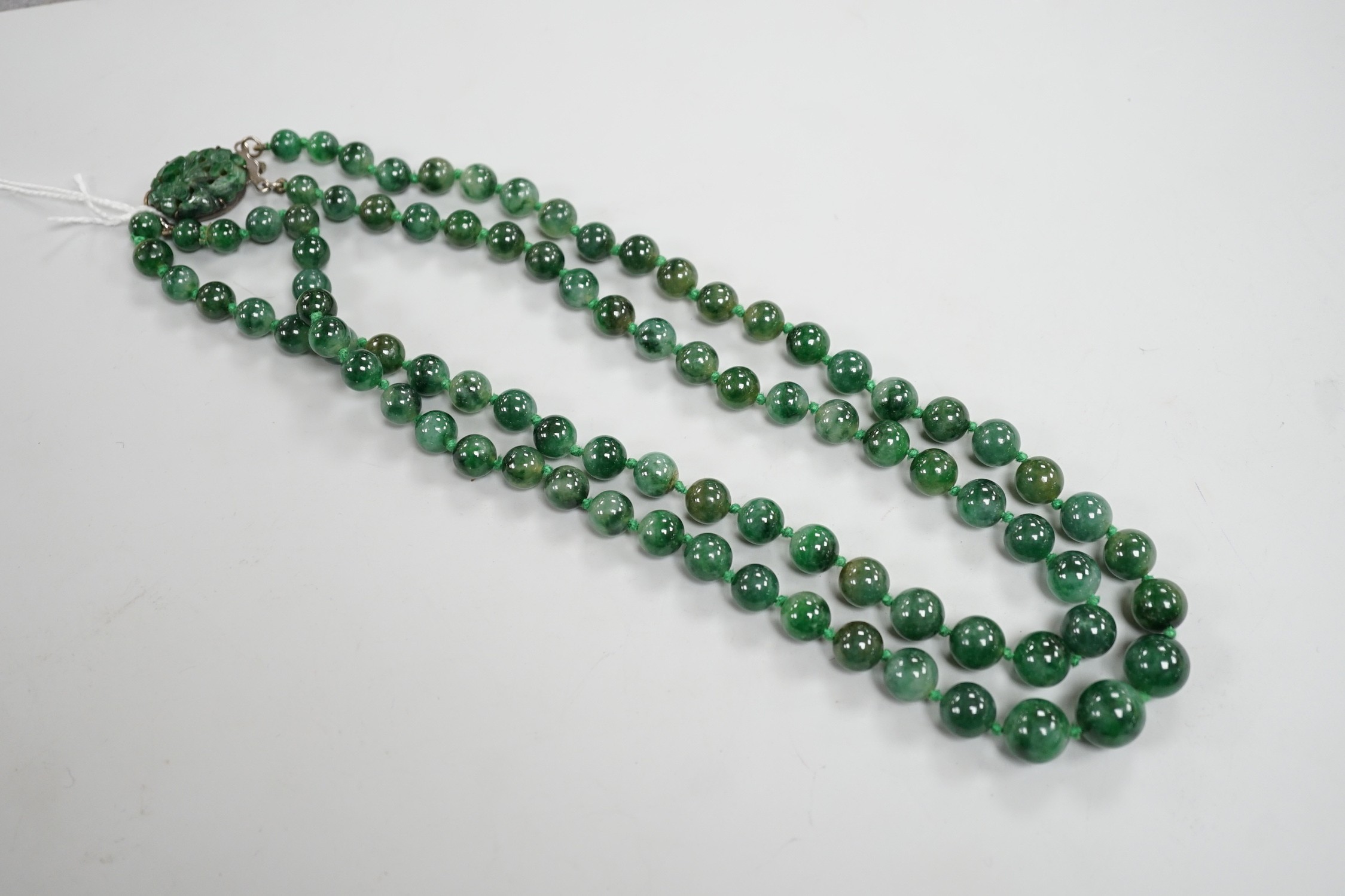A double strand jade bead necklace, with carved jade and white metal clasp, 45cm, gross weight 101 grams.